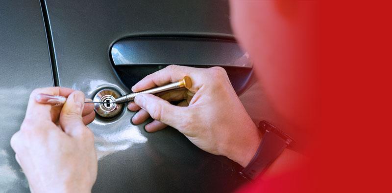 specjalista otwiera zamek w drzwiach samochodu bez kluczyka